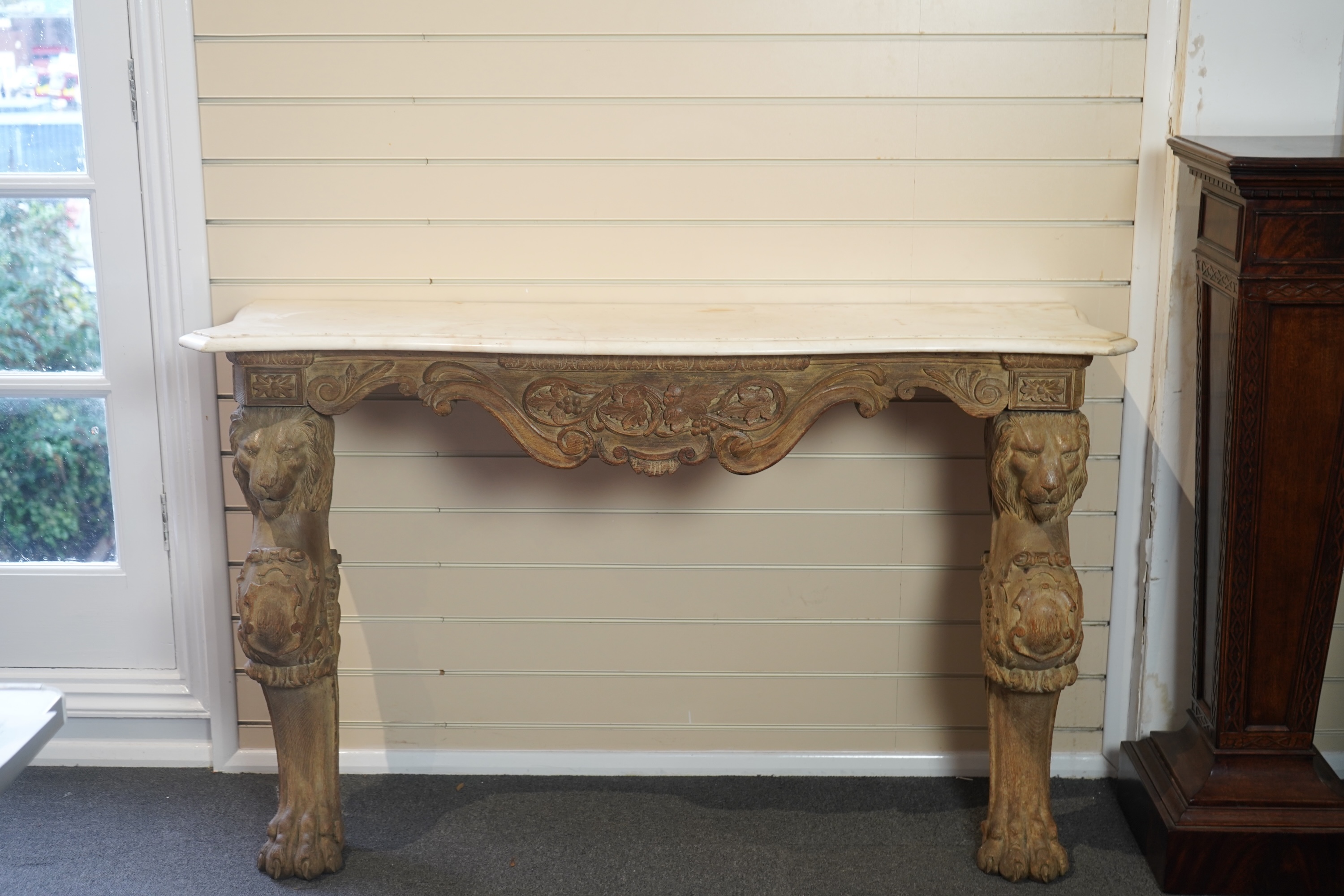 A 19th century Baroque style marble topped limed oak serpentine console table